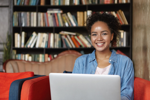 Etudiante travaillant dans une bibliothèque sur son ordinateur